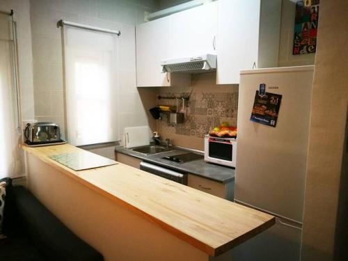 La cuisine est équipée d'un comptoir et d'un réfrigérateur. dans l'établissement Apartamento Urgel, à Madrid