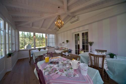una sala da pranzo con tavolo e fiori di Rose e Merletti a Sasso Feltrio