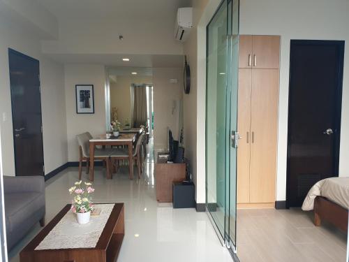 a living room with a table and a dining room at One Pacific Residence Condominium Tower C-16N in Mactan