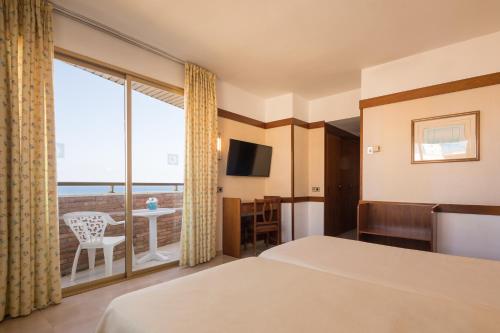 Habitación de hotel con cama y balcón en htop Royal Sun #htopFun, en Santa Susanna
