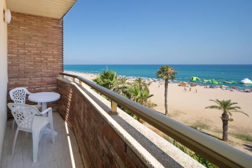 a balcony with a table and chairs and the beach at htop Royal Sun - Fun in Santa Susanna
