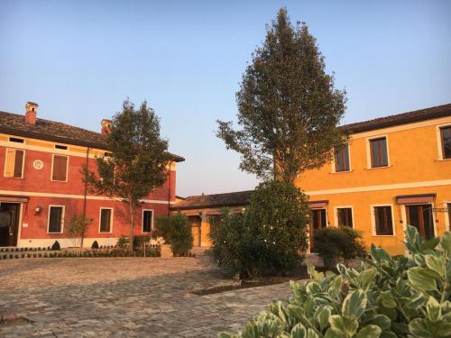 a group of buildings with a tree in a courtyard at Agriturismo Corte Palazzo in Marcaria