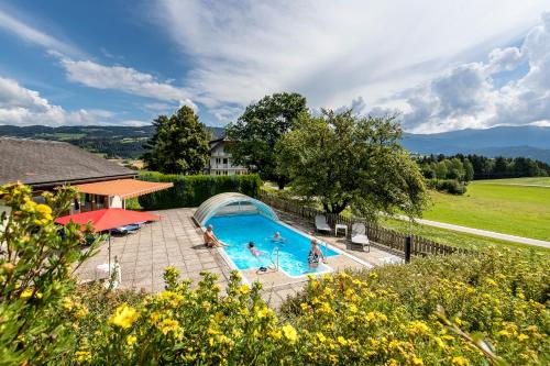 einen Blick über einen Pool mit Menschen darin in der Unterkunft Hotel Gasthof zur Linde in Mariahof