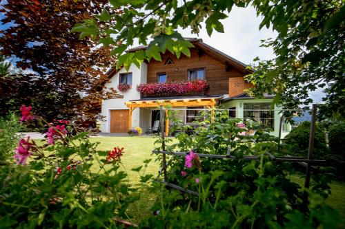 a house with a bunch of flowers in the yard at Hotel Gasthof zur Linde in Mariahof