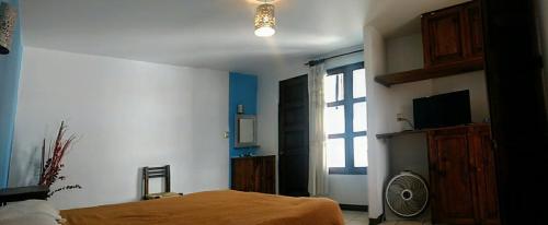 a bedroom with a bed and a window and a fan at HOTEL NIUT-JA in Oaxaca City