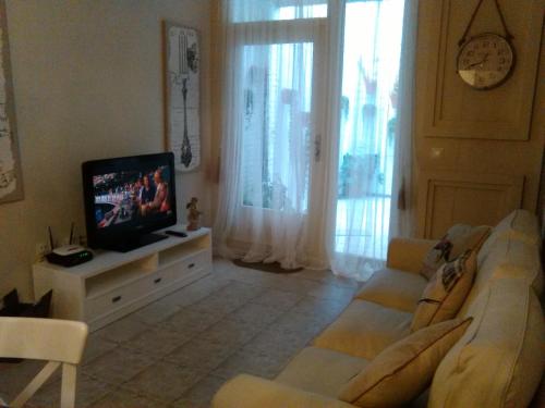 ein Wohnzimmer mit einem Sofa und einem TV in der Unterkunft Apartamento Romántico in Valencia