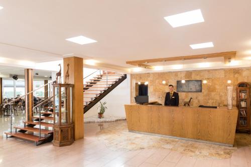a man standing at a desk in a lobby at htop Palm Beach SPA - Fun in Lloret de Mar