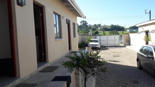 a car parked in a parking lot next to a house at Emampingeni lodge in Bizana