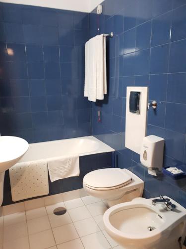 a white toilet sitting next to a bathroom sink at Luso Brasileiro in Póvoa de Varzim