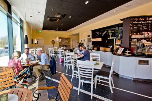 a group of people sitting at tables in a restaurant at MyRoom - Top Munich Serviced Apartments in Munich