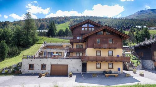 uma casa grande com uma varanda em cima em Residence Baita Cusini em Livigno