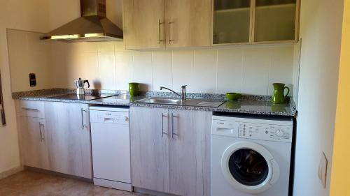 a kitchen with a sink and a washing machine at Atic Casa Llebra in Roquetas