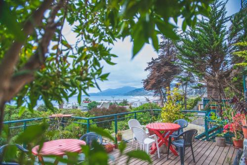 a patio with tables and chairs and a view of the water at Cabañas El Bosque in Maitencillo