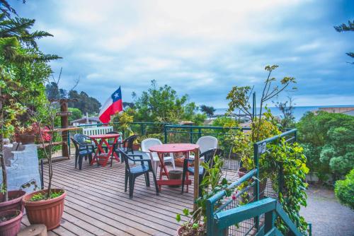 a deck with tables and chairs and a flag at Cabañas El Bosque in Maitencillo