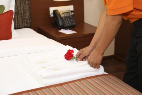 a person placing a flower on a bed at Mountain Glory Forest Resort in Pokhara