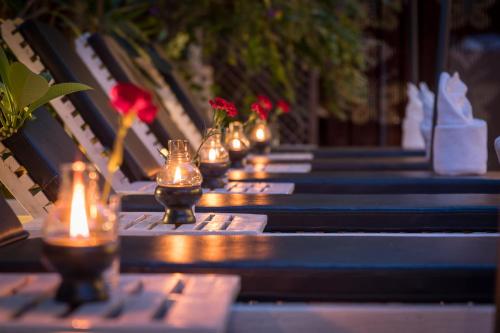 a row of benches with candles and flowers on them at Chandara Boutique Hotel in Vientiane