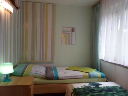 a small bedroom with two beds and a window at Ferienwohnung "Waldesruh" in Eibenstock