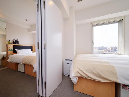 a bedroom with two beds and a window at Super Hotel JR Nara Ekimae Sanjo Dori in Nara