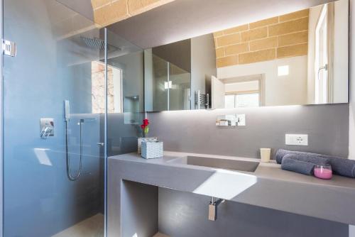 y baño con lavabo y ducha con espejo. en Villa Arja en Corsano