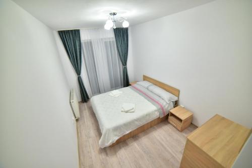 Habitación pequeña con cama y mesa en City Residence Sibiu, en Sibiu