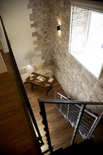 a room with a staircase with a table and a brick wall at Hotel & Residenza 100 Torri in Ascoli Piceno