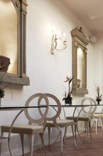 a dining room with a table and chairs and mirrors at Hotel & Residenza 100 Torri in Ascoli Piceno