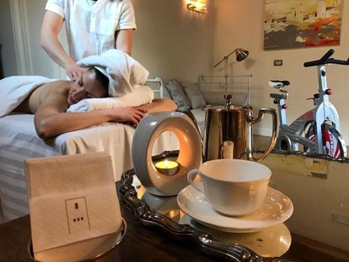 a woman laying in a hospital bed with a table with a cup at Hotel & Residenza 100 Torri in Ascoli Piceno