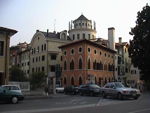 um grupo de carros estacionados em frente a um edifício em LOFT "Residenza dei TOLOMEI" - Sacile em Sacile