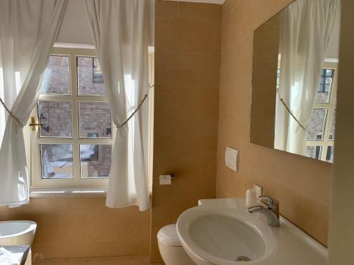 a bathroom with a sink and a toilet and a window at Hotel & Residenza 100 Torri in Ascoli Piceno