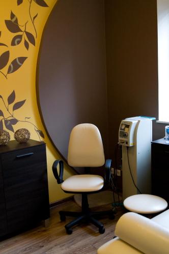 a room with a white chair and a desk at Bagińscy Spa in Pobierowo