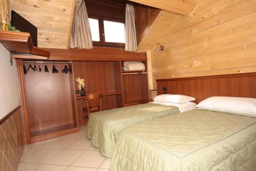 two beds in a room with wooden walls at Hotel Astrid in Milan