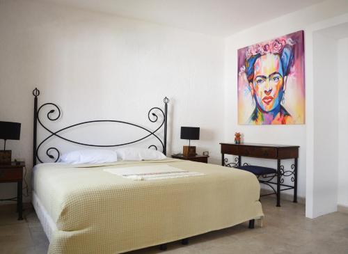 una camera da letto con un letto e un quadro sul muro di Kinta Kan Hotel Boutique Cozumel a Cozumel