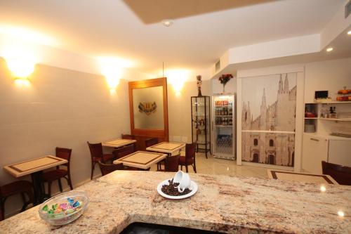 a room with tables and chairs and a counter top at Hotel Astrid in Milan