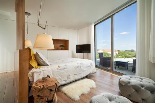 a bedroom with a bed and a large window at Oliveira House in Castelo Novo