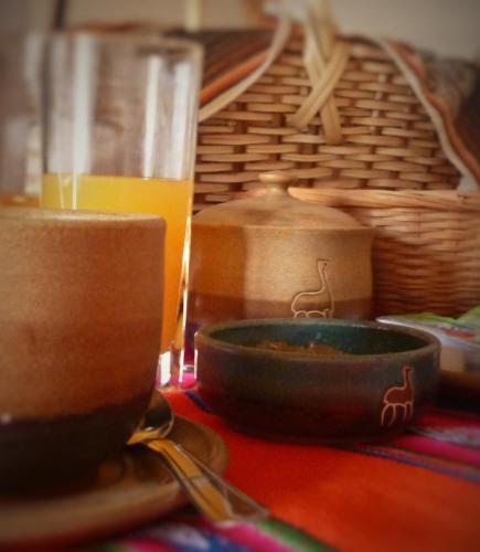 a table with a bowl of food and a glass of orange juice at Casatilcara Cabañas in Tilcara