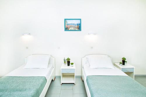 two beds in a room with white walls at Xenios Port Marina Hotel in Pefkohori