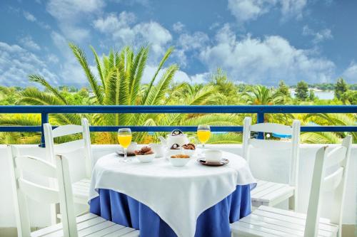 a table with drinks and food on a balcony at Xenios Port Marina Hotel in Pefkohori