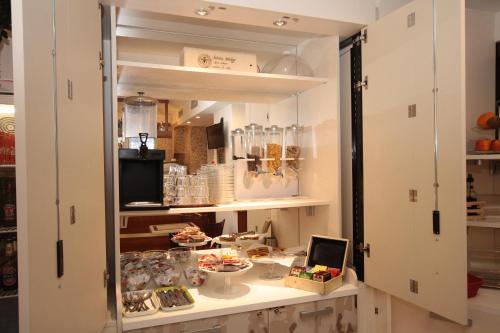 a room with a shelf with food and other items at Hotel Astrid in Milan