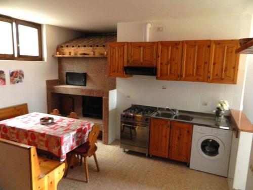 a kitchen with a table and a stove top oven at Appartamento Morena in Malcesine