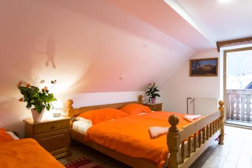 ein Schlafzimmer mit einem orangenen Bett und einem Fenster in der Unterkunft Apartment Ivanka Cvetek in Bohinj