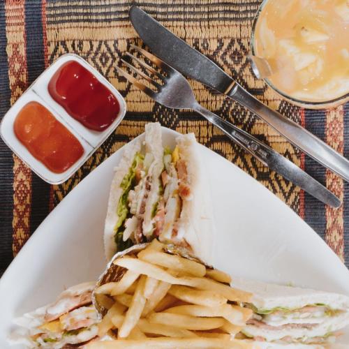 a sandwich and french fries on a plate with ketchup at Borobudur Bed & Breakfast in Borobudur