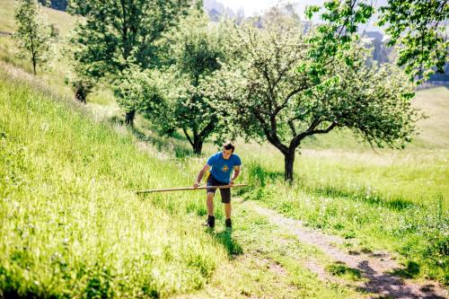 a man walking down a dirt road with a stick at Gutzingerhof in Bad Kleinkirchheim
