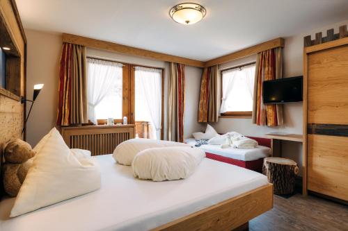 a hotel room with two beds and a television at Kinderhotel Laderhof in Ladis