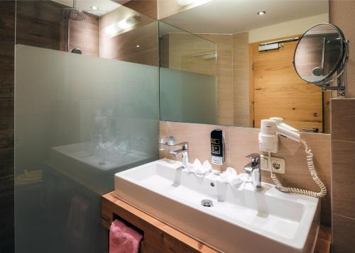 a bathroom with a sink and a mirror at Kinderhotel Laderhof in Ladis