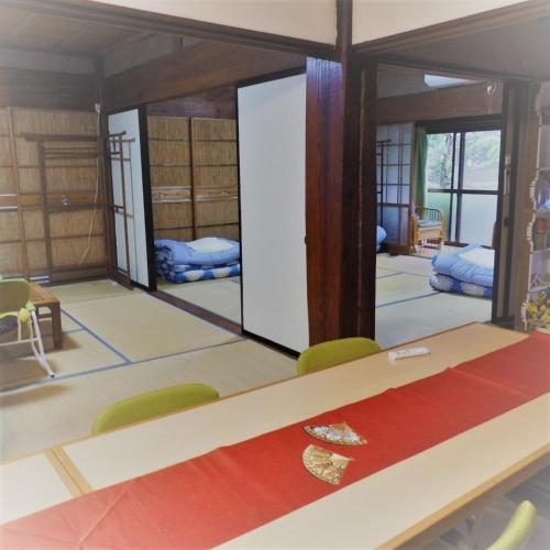 Zimmer mit Tisch und Stühlen und Zimmer mit Betten in der Unterkunft Minshuku Mariko / Vacation STAY 895 in Mochimune