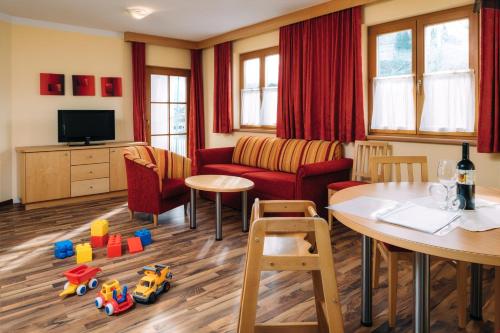 a living room with a couch and a table at Kinderhotel Laderhof in Ladis
