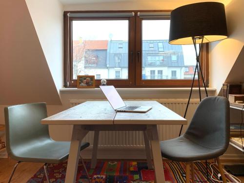 einen Tisch mit einem Laptop mit zwei Stühlen in der Unterkunft Hinterhaus Apartment No1 in Leipzig
