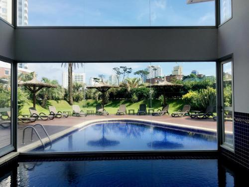 una piscina en una casa con una ventana grande en South Beach Apartment, en Punta del Este