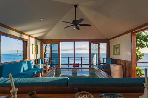 a living room with a couch, chairs, and a large window at The Sea Cliff Hotel Resort & Spa in Port Antonio