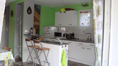 a kitchen with white cabinets and green walls at Les coquelicots in Luz-Saint-Sauveur